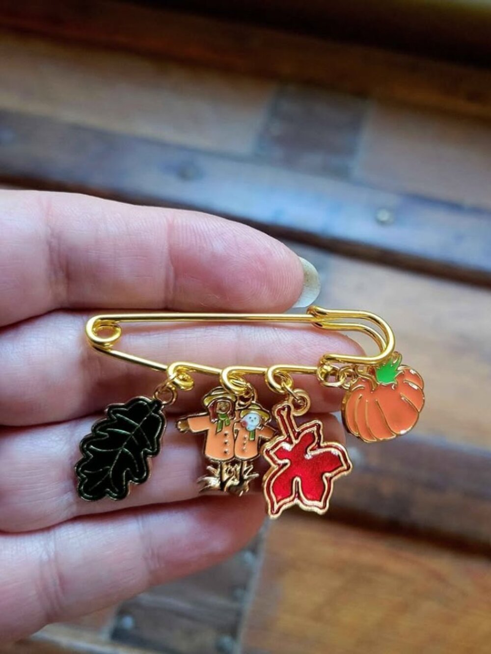 Gold-tone safety pin brooch decorated with autumn and Thanksgiving-themed enamel